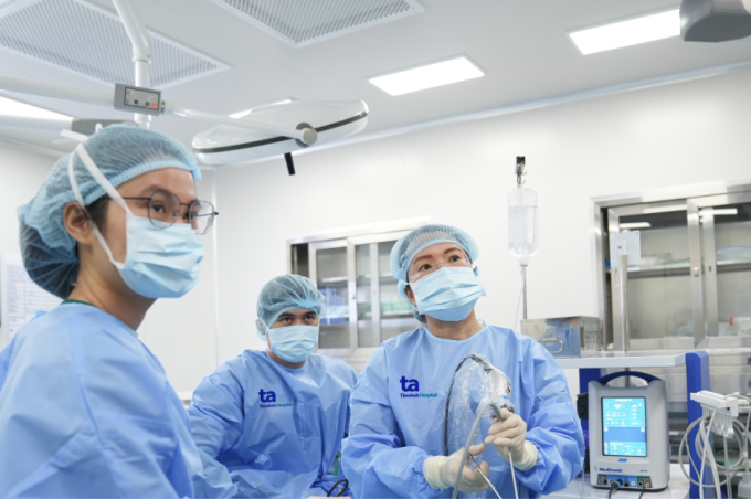 [Pie de foto] El doctor Hang (derecha) durante una cirugía de pólipo de cuerda vocal a mediados de marzo. Foto: Hospital General de Tam Anh