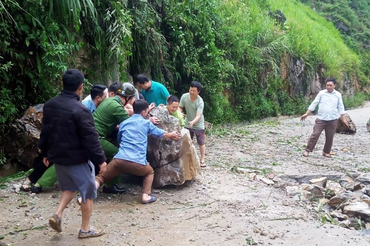 Lực lượng chức năng và người dân dọn dẹp hiện trường vụ sạt lở.