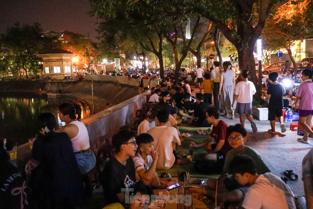 People spread mats and set up tables to drink coffee in the middle of Ngoc Khanh Lake walking street, photo 13