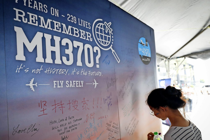 คนข้างกำแพงอนุสรณ์สถานเครื่องบิน MH370 ที่ประสบเหตุร้ายแรง (ภาพ: RND)