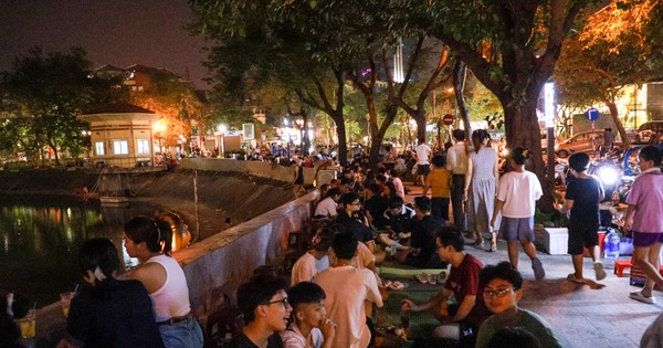 People spread mats and set up tables to drink coffee in the middle of Ngoc Khanh Lake walking street.