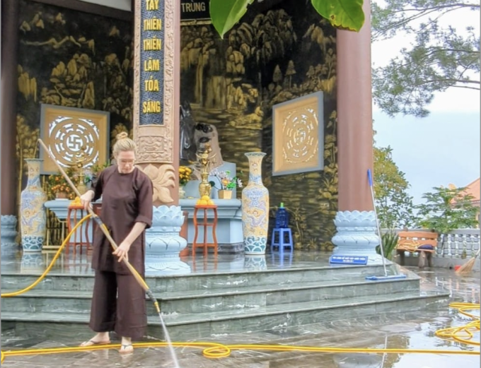 Claudia hilft im Februar 2024 beim Reinigen des Hofs des Truc Lam Tay Thien Zen-Klosters in der Provinz Vinh Phuc. Foto bereitgestellt von Character