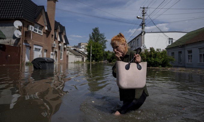 Una mujer camina por una calle inundada en Kherson después de que la presa de Kakhovka se rompiera el 6 de junio. Foto: AP