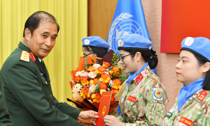 Generalleutnant Phung Si Tan (links) überreicht drei Soldatinnen die Entscheidung des Präsidenten. Foto: Zeitung der Volksarmee