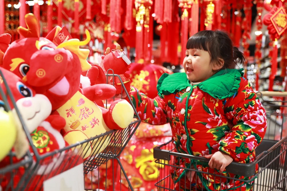 Los niños disfrutan mirando las decoraciones del Año Nuevo Lunar en un supermercado de la provincia de Guizhou, China. (Foto: THX/TTXVN)