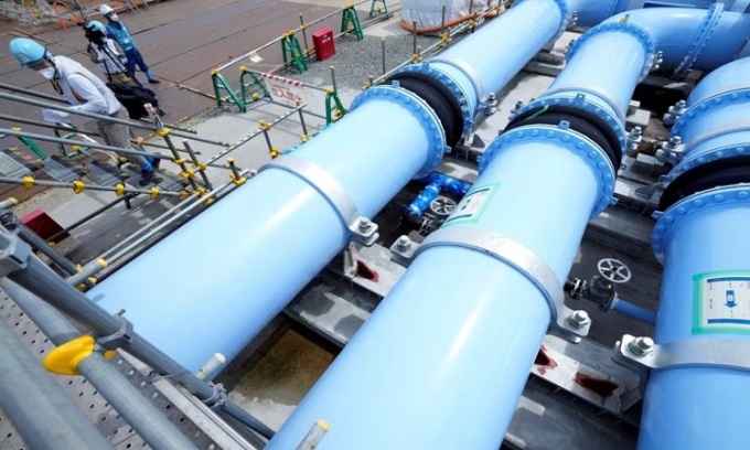 The green pipe brings in seawater to dilute the treated radioactive water. Photo: Reuters