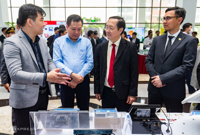 El ministro Huynh Thanh Dat (tercero desde la izquierda) visitó la exposición de tecnología de chips semiconductores con docenas de stands que presentaban proyectos de investigación y modelos de productos altamente aplicables en la Universidad Nacional de Hanoi en abril de 2023. Foto: Tung Dinh