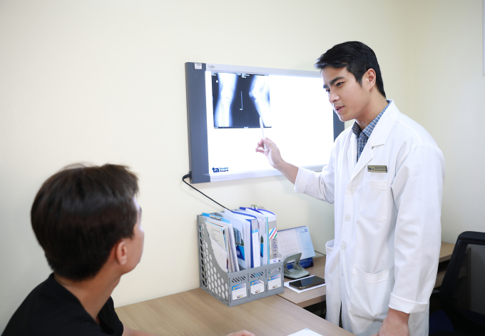 Le docteur An consulte le patient sur son état de genou. Photo : Hôpital fourni