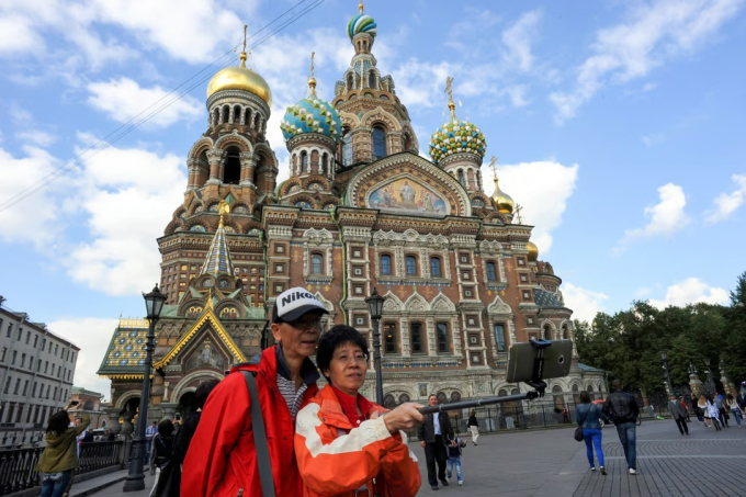 Chinese tourists take photos with selfie sticks in St Petersburg. Photo: AP