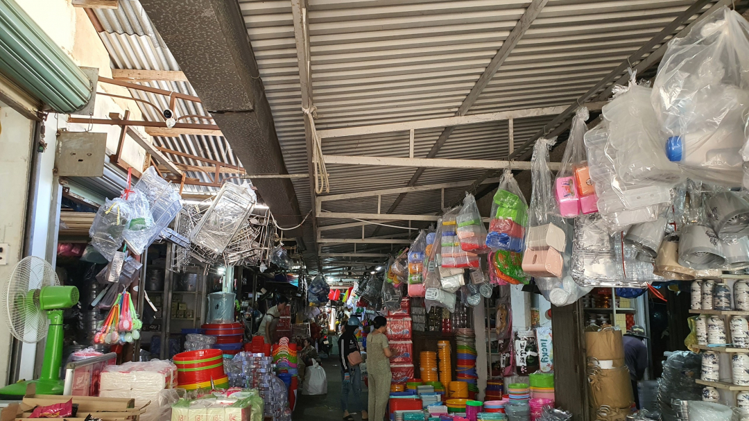 Many small traders at the New Market display their goods, taking up the entire aisle.