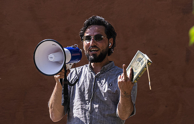 Salwan Momika tient un Coran lors d'une manifestation devant une mosquée à Stockholm, en Suède, le 28 juin. Photo : AFP