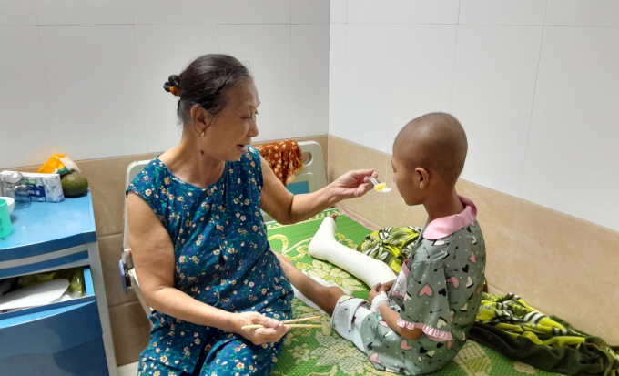 Ms. Nguyen Thi Duoc, 76 years old, is taking care of her grandchild Luu Xuan Giang, 9 years old, at Hai Phong Children's Hospital, on the afternoon of July 8. Photo: Hai Anh