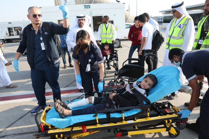 Des volontaires transportent un enfant palestinien blessé hors de l'avion à son arrivée à Abou Dhabi le 18 novembre, après avoir été évacué de Gaza dans le cadre d'une mission humanitaire organisée par les Émirats arabes unis. Giuseppe Cacace/AFP/Getty Images