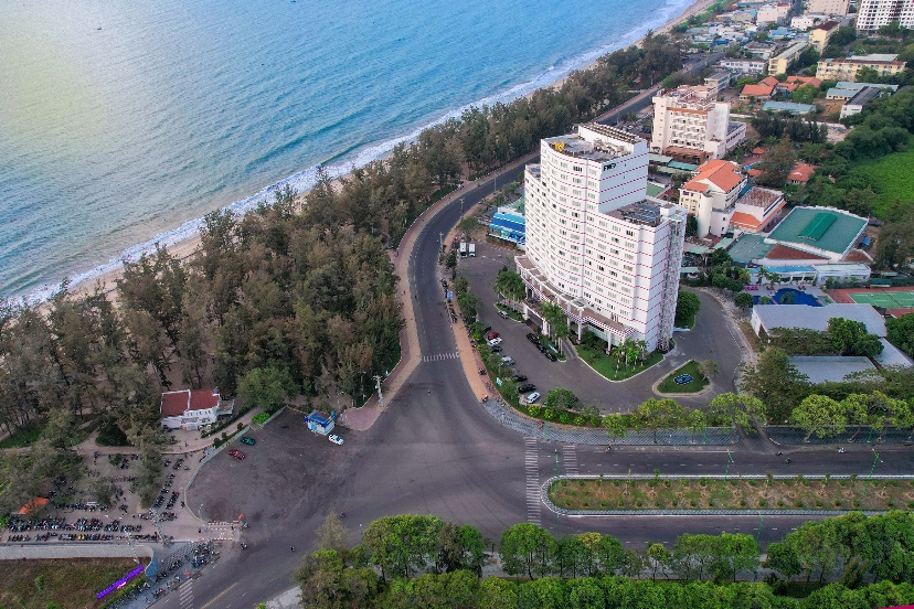 A road next to a beach  Description automatically generated