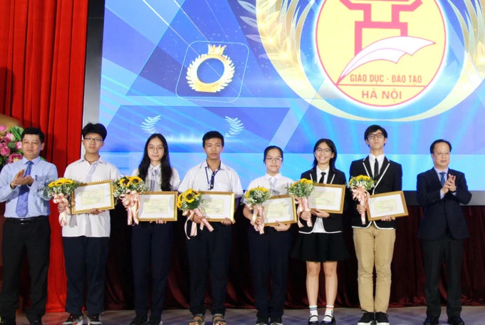 Seis miembros del equipo estudiantil que participan en la Olimpiada Internacional de Ciencias Juveniles de 2024 (centro de la foto) con líderes del Departamento de Educación y Capacitación de Hanoi.