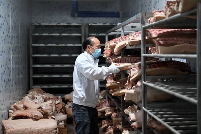 Employees arrange pork in a warehouse in Hainan (China). Photo: Xinhua