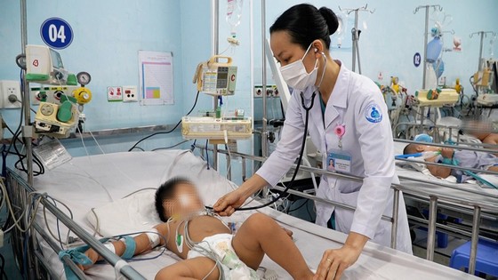 Doctors at Children's Hospital 1 (HCMC) examine a child with hand, foot and mouth disease. Photo: THANH SON