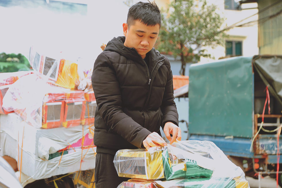 Anh Dũng lựa chọn vàng mã ông Công ông Táo tại làng Phúc Am. Ảnh: HẢI ĐĂNG