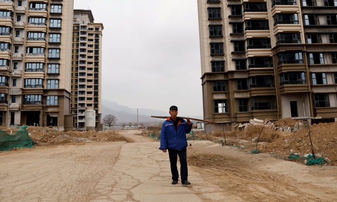 Ein Mann geht an unfertigen Wohnhäusern vorbei, die von China Evergrande am Stadtrand von Shijiazhuang in der chinesischen Provinz Hebei gebaut wurden, Februar 2024. Foto: Reuters