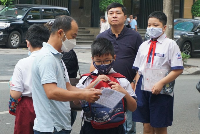 Los padres llevan a sus hijos a tomar el examen de ingreso para el sexto grado en la escuela secundaria Tran Dai Nghia para superdotados, 2023. Foto: Le Nguyen