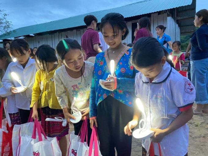 Les étudiants du VAS offrent des cadeaux et des lampes solaires fabriquées artisanalement aux enfants des zones reculées. Photo : Équipe du projet Éclairer les connaissances