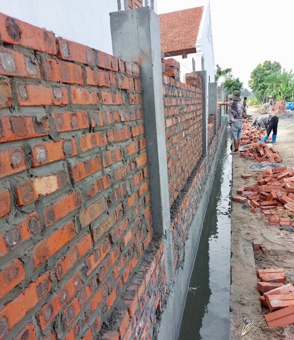 Die Mauer, die das Gemeinschaftshaus Thanh Chieu umgibt, ist ein Relikt aus der Bauphase (bevor es einstürzte).