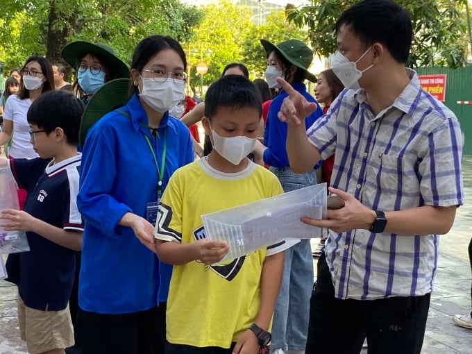 ឪពុក​ម្តាយ​នាំ​កូន​ទៅ​ប្រឡង​មធ្យម​សិក្សា​ភាសា​បរទេស​ជំនាន់​ទី​៦ នៅ​ព្រឹក​ថ្ងៃ​ទី​២៨ ខែ​ឧសភា។ រូបថត៖ Binh Minh