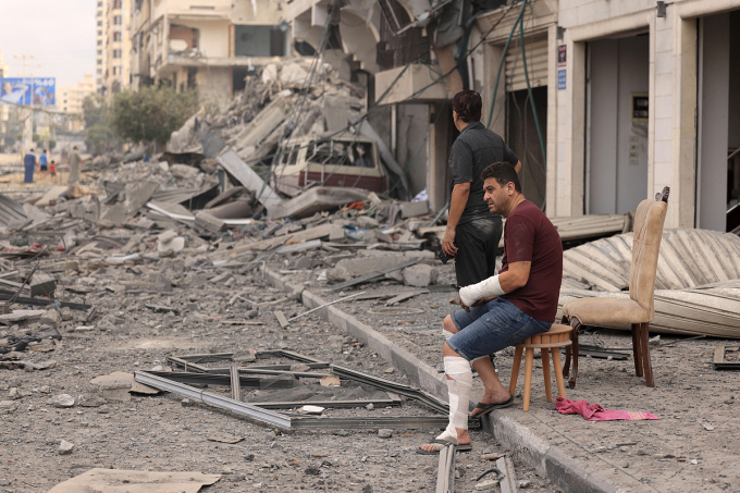 Palästinensische Männer vor einem beschädigten Wohnhaus nach einem israelischen Luftangriff in Gaza-Stadt am 10. Oktober. Foto: AFP