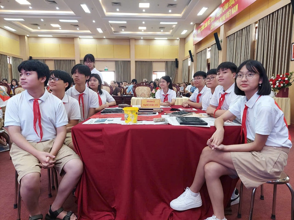 Estudiantes de la escuela secundaria Di Trach, distrito de Hoai Duc, en el papel de jóvenes artesanos de la aldea de pintura popular de Kim Hoang.