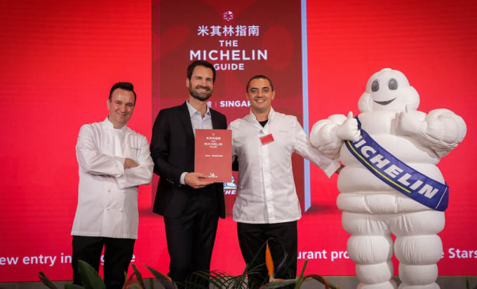 Đại diện Michelin chụp ảnh cùng các đầu bếp và linh vật của Michelin trong một buổi trao sao tại Singapore. Ảnh: Guide. Michelin