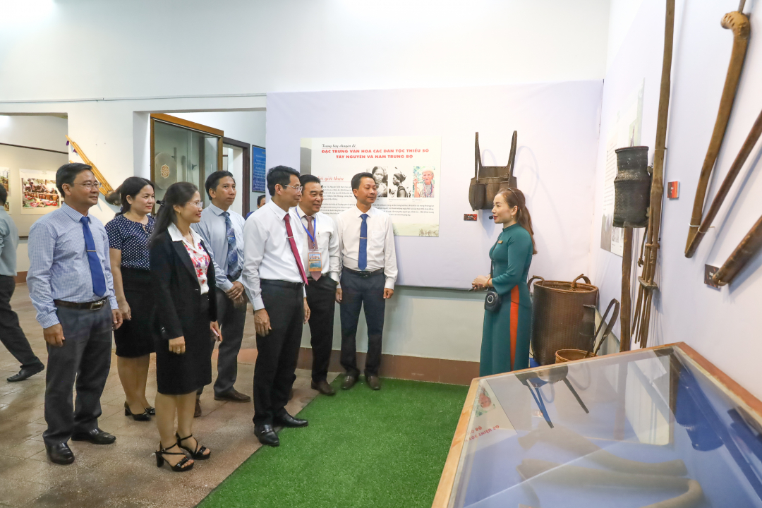Các đại biểu nghe giới thiệu về các hiện vật, hình ảnh được triển lãm.

