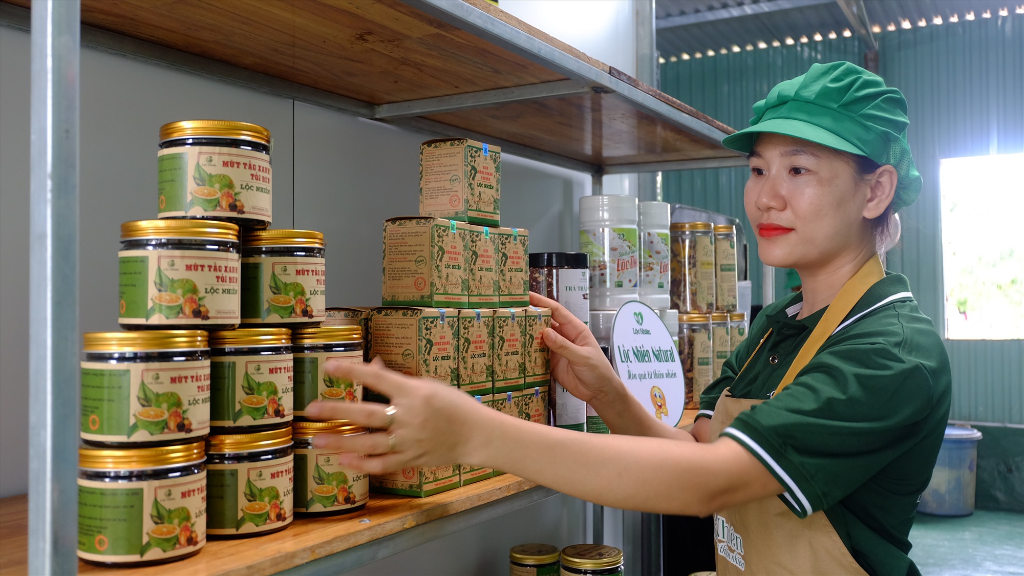 Ms. Ngo Thi Loc and her black garlic lemon basil syrup product. Photo: M.L