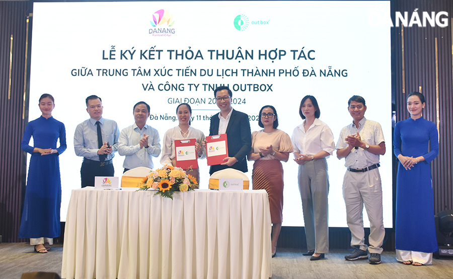 Des représentants du Centre de promotion du tourisme de Da Nang et d'Outbox Company Limited ont signé un accord de coopération. Photo : THU HA