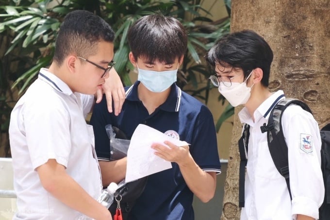 Students exchange papers after the Math and Literature exam for grade 10 at Hanoi National University of Education High School, noon June 1. Photo: Duong Tam