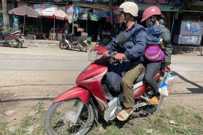 Anh Phạm Văn Thơ chở vợ con vào rẫy để chuẩn bị hái cà phê thuê. Ảnh: Kiều Loan