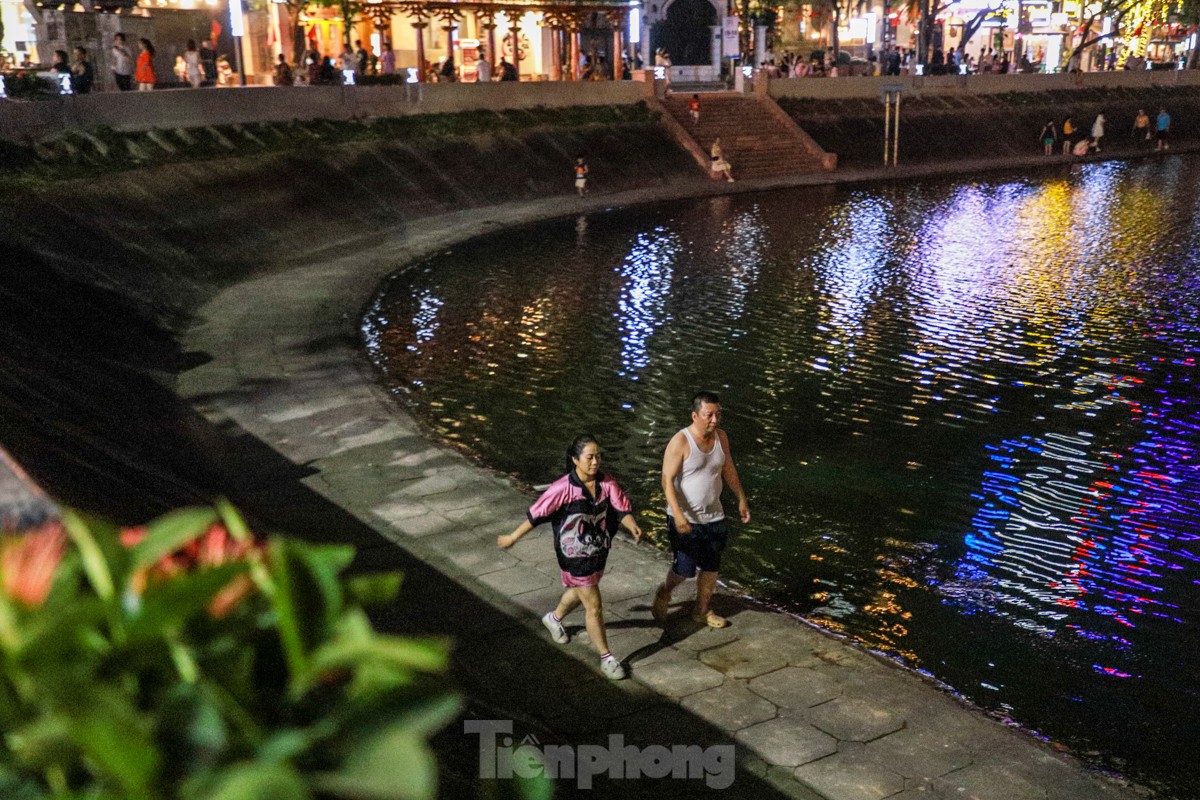 People spread mats and set up tables to drink coffee in the middle of Ngoc Khanh Lake walking street, photo 6