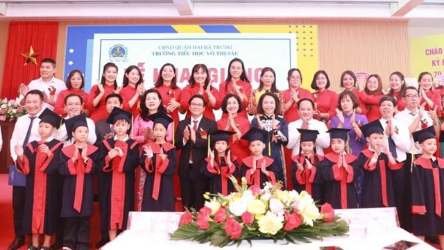 Los líderes de la ciudad celebran con los estudiantes del distrito de Hai Ba Trung en la ceremonia de apertura.