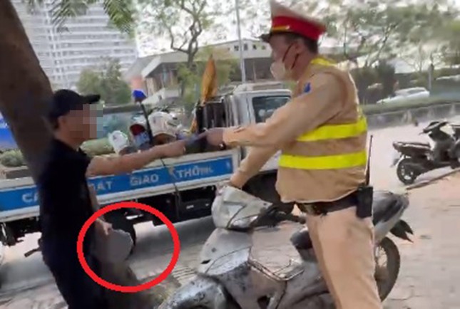 Un hombre usa un ladrillo para destrozar una motocicleta en un control de tráfico (foto 1)