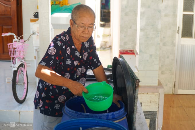 Ông Kiên dự trữ nước mưa trong những thùng nhựa lớn để phục vụ tưới tiêu. Ảnh: Bùi Toàn