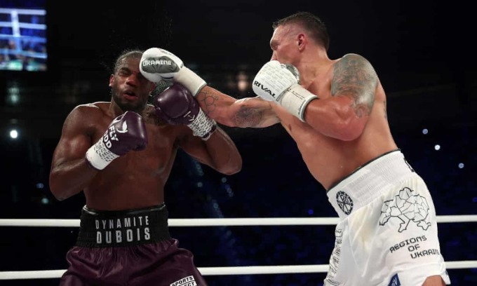 Usyk (quần trắng, găng trắng) trong một đòn đánh trúng đầu Dubois trên võ đài Wroclaw, Ba Lan ngày 26/8. Ảnh: Reuters