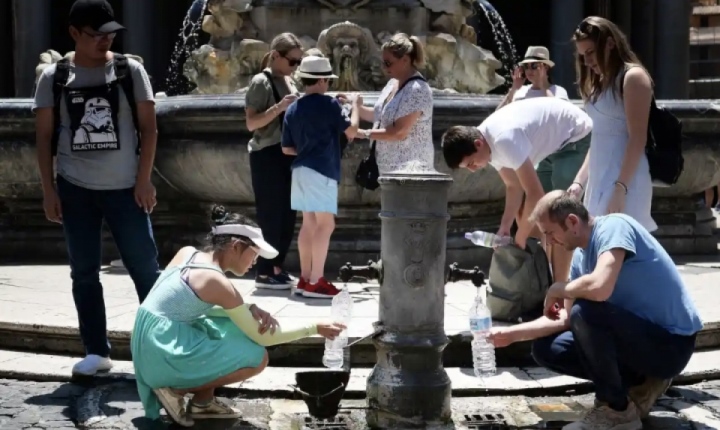 Touristen in Rom trinken während einer ungewöhnlichen Hitzewelle aus einem öffentlichen Brunnen.