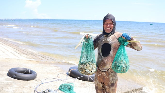 Ngư dân Nguyễn Năm với số nghêu vừa lặn lên ở biển Rạng, TP Phan Thiết. Ảnh: Việt Quốc