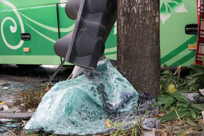 Traffic lights and broken car windows lie under a tree by the roadside. Photo: Lam Son