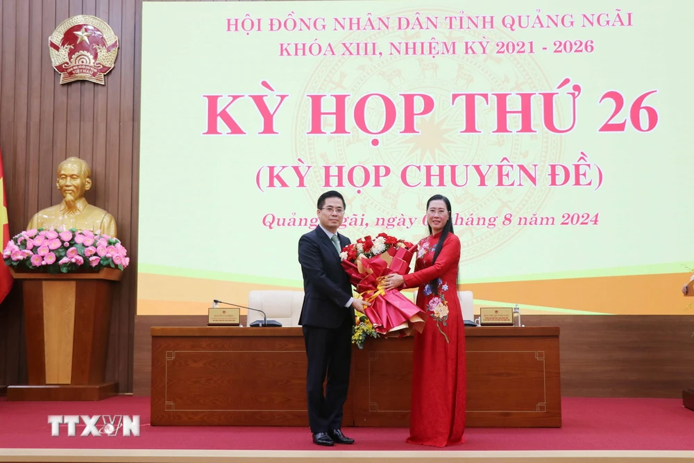 บุ้ย ถิ กวินห์ วัน เลขาธิการคณะกรรมการพรรคประจำจังหวัดกวางงาย มอบดอกไม้ให้แก่เหงียน ฮวง เกียง ประธานคณะกรรมการประชาชนประจำจังหวัดคนใหม่ (ซ้าย) (ภาพถ่าย: Pham Cuong/VNA)