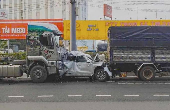 После аварии деформированный 4-местный автомобиль оказался зажат между тягачом и грузовиком. Фото: Нгуен Лонг