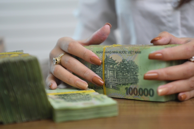 Los clientes realizan transacciones en un banco comercial en Hanoi. Foto: Giang Huy