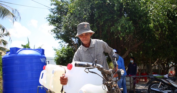 People in the West wait day and night to collect cans of water.