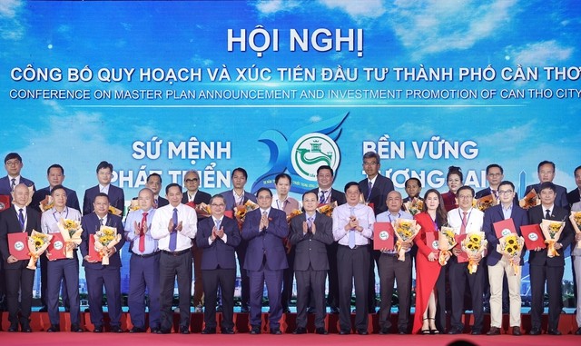 Thủ tướng và lãnh đạo TP. Cần Thơ tặng hoa chúc mừng các doanh nghiệp và đơn vị được trao biên bản ghi nhớ chủ trương đầu tư . (Nguồn: VGP)