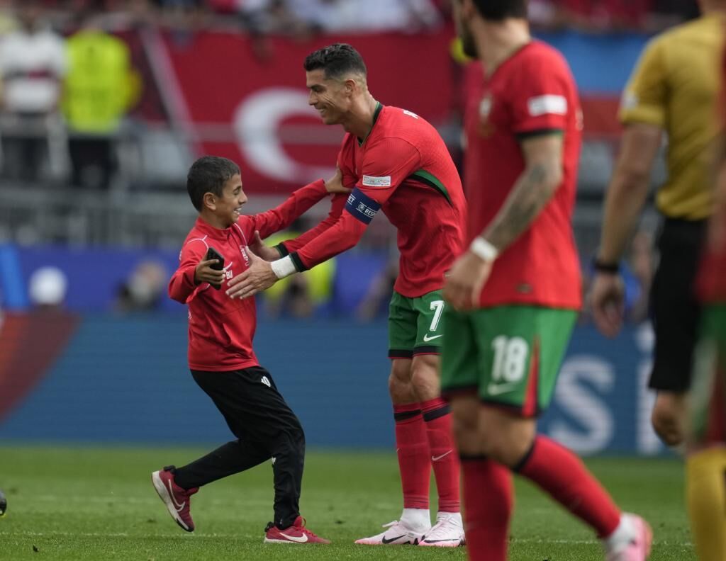 CĐV nhí 'vượt rào' chạy vào sân, có ngay ảnh để đời với Ronaldo- Ảnh 1.