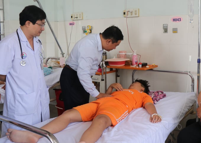 Deputy Director of the Department of Health Trinh Ngoc Hiep (bowing) visits a poisoning patient being treated at Khanh Hoa General Hospital on the afternoon of March 14. Photo: Bui Toan